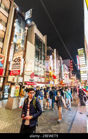Dotonbori, the entertainment center of Osaka at night. Main street crowded with tourists walking between the restaurants and brightly lit neon signs Stock Photo