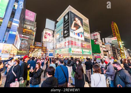 The Popular crowded Ebisu bridge at Dotonbori, Osaka. Wide view from Shin Sai Bashi Suji shopping arcade entrance to the Don Quixote Ferris wheel. Nig Stock Photo