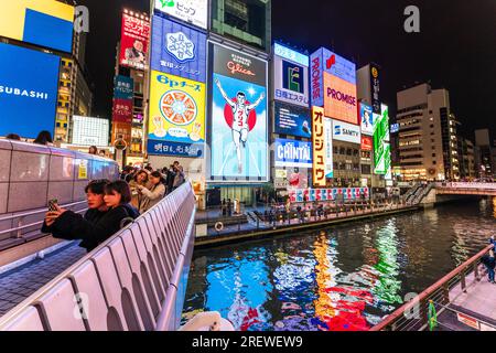 View from the Ebisu bridge at night of the famous Glico Running Man neon light display at Dotonbori, Osaka, the sign abstractly reflected in the river Stock Photo