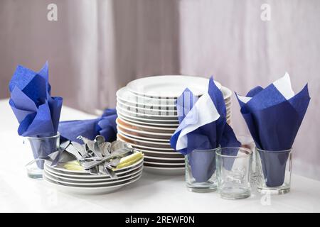 A stack of empty plates and napkins in a restaurant on a table. Stock Photo
