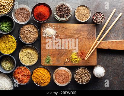 Colorful ingredients, herbs and spices for cooking dishes. Asian spices for Chinese cuisine concept with cutting board background for free space for m Stock Photo