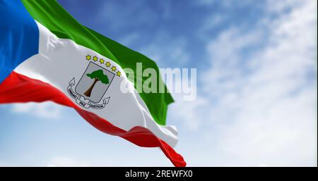 National flag of Equatorial Guinea waving in the wind on a clear day. Horizontal tricolor, with green, white and red stripes and a blue triangle at th Stock Photo