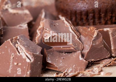 broken into several parts pieces of chocolate from cocoa, natural food and pastries from cocoa, sugar, cocoa butter, pieces of large natural real choc Stock Photo