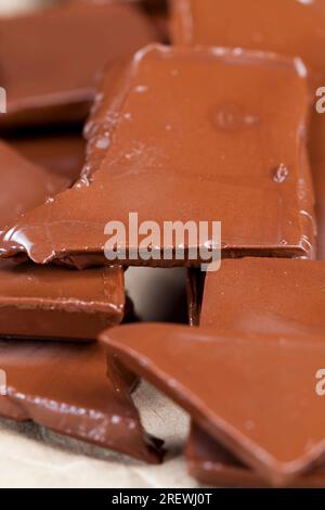 milk and bitter chocolate together are broken into pieces with a melted surface, melted several pieces from broken chocolate of different types, Stock Photo