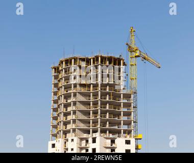 construction of a new monolithic building with a large number of apartments, a building on the edge of the city in a new urban area, construction of n Stock Photo