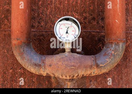 A broken rusty pressure gage on a rusty pipeline Stock Photo