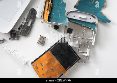 Broken smartphone. The insides of a dropped smartphone in a white case. close-up top view Stock Photo