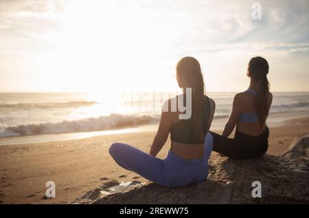 Calm slim woman practicing yoga and meditating, enjoying training on beach  near sea, exercising Stock Photo by Prostock-studio