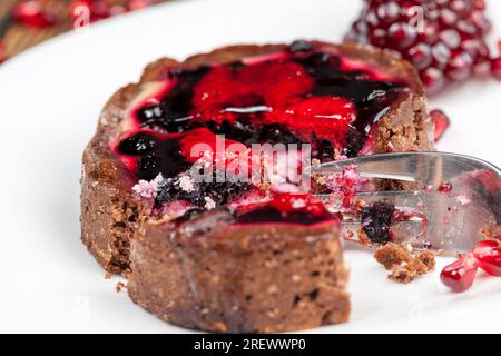 dessert of baked tartlets, chocolate tartlet with fruit and berry filling, round tartlet with strawberries and blueberries in butter cream Stock Photo