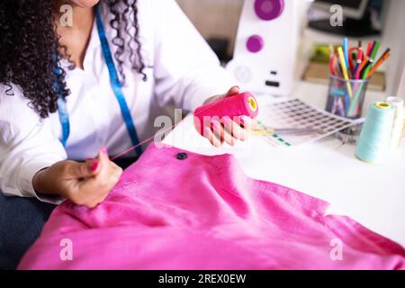 Seamstress Woman Choosing Thread Sitting Near Sewing Machine Indoor, Cropped Stock Photo