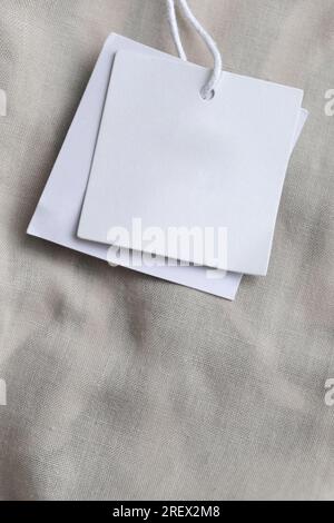 Close up of price tag of clothing item. Blank label tag mockup on clothes. Fashion industry and retail concept. Stock Photo