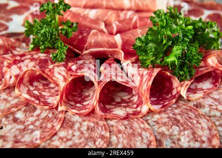 Plate with Assorted different types of smoked sausages, salami and meat, close up Stock Photo