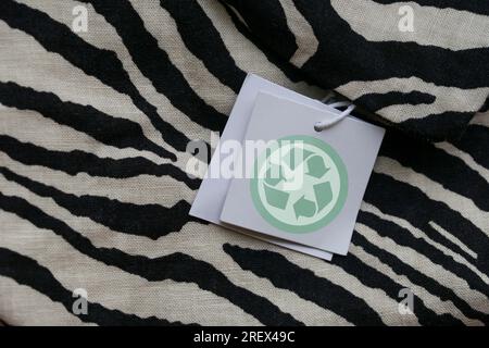 Close up of clothing tag with recycle icon. Recycling products concept. Zero waste, suistainale production, environment care and reuse concept Stock Photo