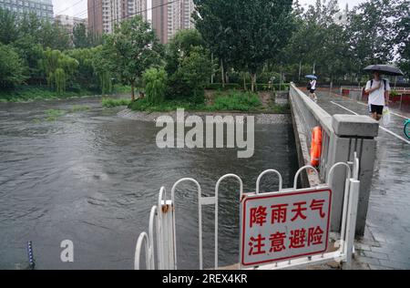 Beijing, China. 30th July, 2023. People walk amid the rain in Beijing, capital of China, July 30, 2023. Impacted by Typhoon Doksuri, the fifth typhoon of this year, heavy rainfall has hit north China regions, including Beijing, Hebei and Shandong. Credit: Zhang Chenlin/Xinhua/Alamy Live News Stock Photo