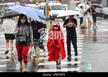 Beijing, China. 30th July, 2023. People walk amid the rain in Beijing, capital of China, July 30, 2023. Impacted by Typhoon Doksuri, the fifth typhoon of this year, heavy rainfall has hit north China regions, including Beijing, Hebei and Shandong. Credit: Ju Huanzong/Xinhua/Alamy Live News Stock Photo