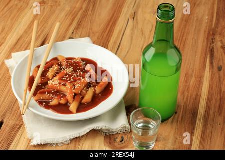 Tteokbokki Korean Rice Cake  with Soju on Wooden Table Stock Photo