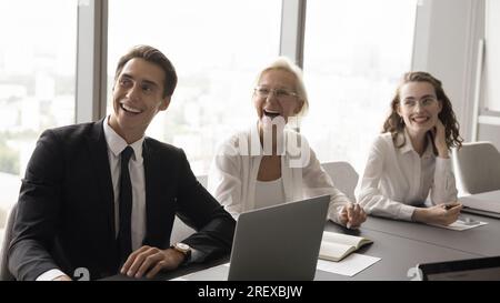 Positive different aged business colleagues laughing on meeting Stock Photo