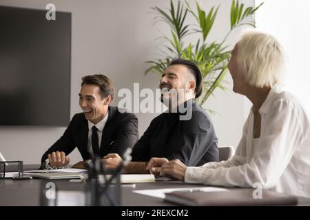 Happy business colleagues relaxing on office meeting, enjoying teamwork Stock Photo
