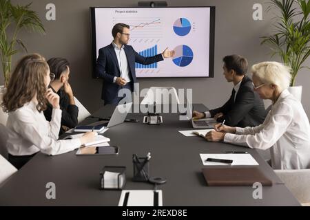 Confident young business leader man presenting marketing statistic report Stock Photo
