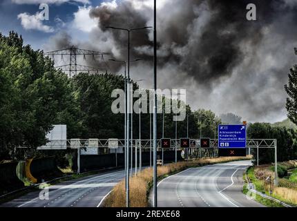 Alblasserdam, Netherlands. 30th July 2023. ALBLASSERDAM - A closed A15 near Alblasserdam due to a very large fire on the roof of a storage company in Alblasserdam causes a lot of smoke development. The fire is raging on a roof with solar panels. Photo: ANP / Hollandse hoogte / Jeffrey Groeneweg netherlands out - belgium out Credit: ANP/Alamy Live News Stock Photo