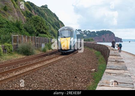 Devon, England – July 21, 2023: Great Western Railway passenger train travelling along the spectacular coastline between Dawlish and Teignmouth Stock Photo