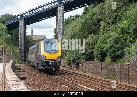 Teignmouth, England – July 21, 2023: A train of the CrossCountry passenger service, part of the Arriva group, having just departed Teignmouth station Stock Photo