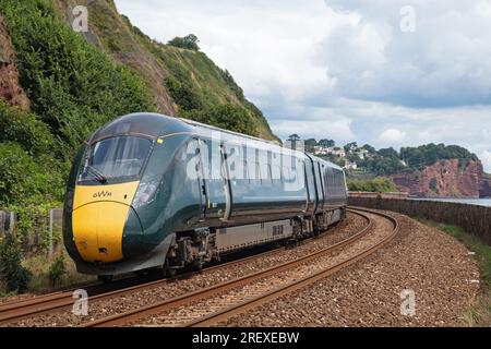 Devon, England – July 21, 2023:  A Hitachi class 800 series train of the Great Western Railway travelling along the spectacular coastal route in Devon Stock Photo