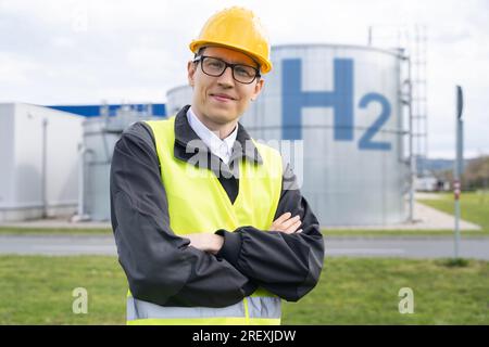 Engineer in helmet on a background of Hydrogen factory. Stock Photo