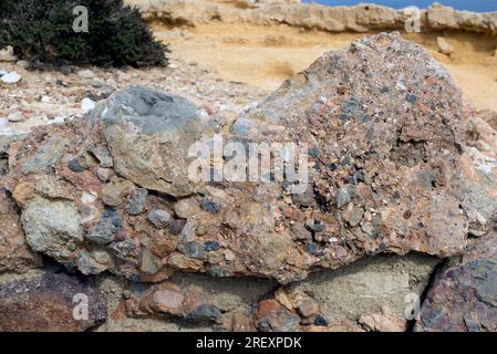 Conglomerate is a clastic sedimentary rock composed by rounded clasts (pudding stone). This photo was take in Cabo de Gata, Almeria, Andalusia, Spain. Stock Photo