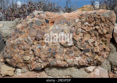 Conglomerate is a clastic sedimentary rock composed of rounded clasts (pudding stone). This photo was take in Cabo de Gata, Almeria, Andalusia, Spain. Stock Photo