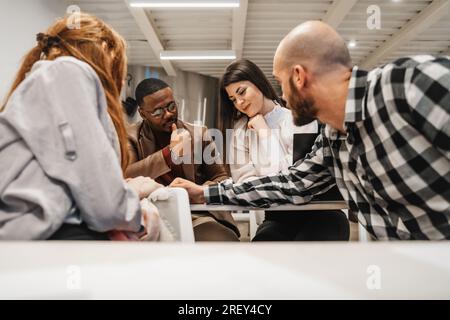 Four multiracial employees working together at the classroom. They are starting up a new project Stock Photo