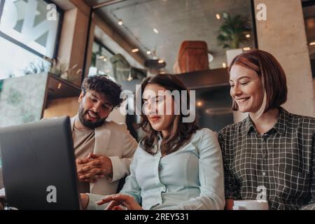 Positive, creative employees working together on lap top at the office Stock Photo