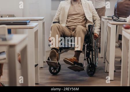 Disabled man in wheelchair. Handicapped male employee. Disabled man rolling wheelchair. Teamwork office. Working together Stock Photo