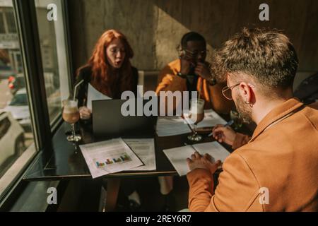 Back view shot of male business person writing in notebook Stock Photo