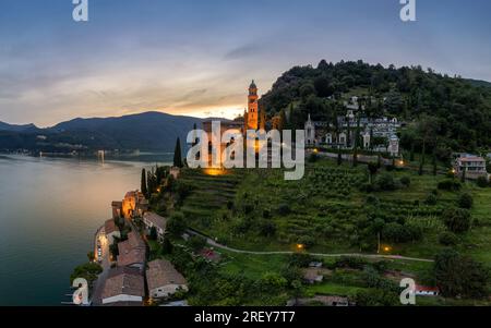 Aerial image of the parish church Madonna del Sasso stands on the high hill of Vico Morcote at sunset. Morcote at the Lake Lugano was once credited as Stock Photo