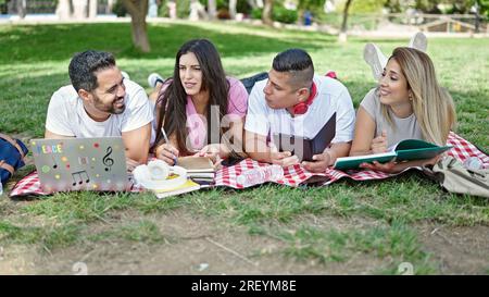 Group of people students using touchpad and laptop studying at park Stock Photo