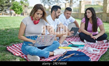 Group of people students using touchpad and laptop studying at park Stock Photo