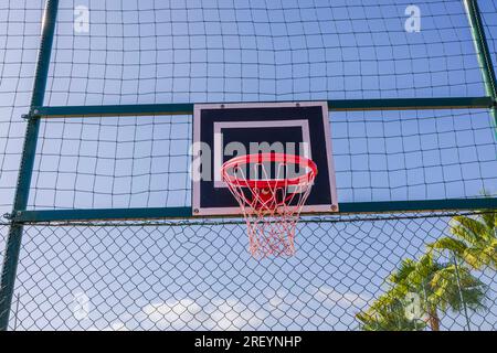 Close-up view of basketball hoop on sports field on blue sky background. Spain. Stock Photo