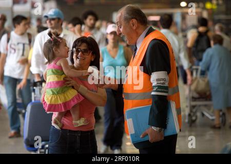 Trenitalia platform staff helping passengers at Milan's busy mainline railway station, the Italian national railway system, 2005 Stock Photo