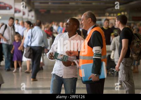 Trenitalia platform staff helping passengers at Milan's busy mainline railway station, the Italian national railway system, 2005 Stock Photo