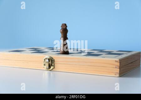 Forgotten chess black king. Chess king alone on a folded chessboard Stock Photo