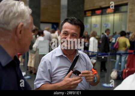 Trenitalia platform staff helping passengers at Milan's busy mainline railway station, the Italian national railway system, 2005 Stock Photo