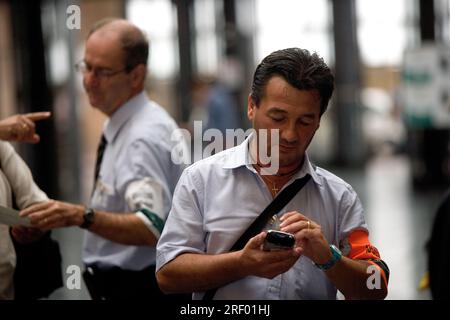 Trenitalia platform staff helping passengers at Milan's busy mainline railway station, the Italian national railway system, 2005 Stock Photo