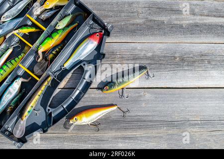 A fishing tackle box, complete with lures and fishing gear on a wooden  background on top. A set of fishing lures for spinning fishing Stock Photo  - Alamy