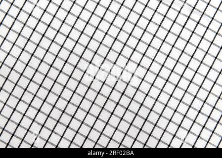 Texture of black and white fabric in a cage. Checkered material. Textile with intersecting white and black lines Stock Photo