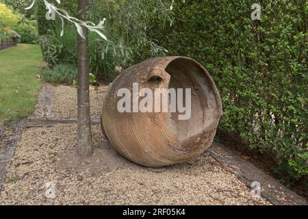 Decorative imitation of a large vintage wine jug. In the garden under a tree. Stock Photo