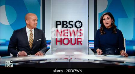 A computer screenshot of a streaming live broadcast of The PBS NewsHour with hosts Geoff Bennett and Amna Nawaz. Stock Photo