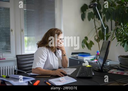 Female doctor at her desk,working on computer Stock Photo
