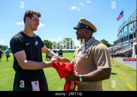 Philadelphia Eagles' Tanner McKee, left, talks to a member of the military  after handing over his jersey during practice at NFL football training  camp, Sunday, July 30, 2023, in Philadelphia. (AP Photo/Chris