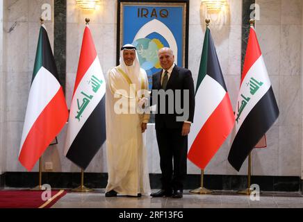 Baghdad, Iraq. 30th July, 2023. Iraqi Foreign Minister Fuad Hussein (R) shakes hands with his Kuwaiti counterpart Sheikh Salem Abdullah Al-Jaber Al-Sabah in Baghdad, Iraq, July 30, 2023. Kuwaiti Foreign Minister Sheikh Salem Abdullah Al-Jaber Al-Sabah paid an official visit to Iraq's capital Baghdad on Sunday and held talks with Iraqi leaders in an attempt to end border demarcation and joint oil field disputes. Credit: Khalil Dawood/Xinhua/Alamy Live News Stock Photo